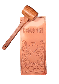 Image of a poker themed leather carved piece with a wooden mallet resting on it