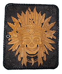 Image of a black leather wallet with hand carved detail of a skull wearing a Native American headdress